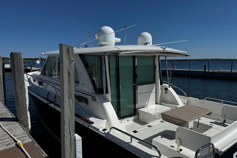 Slide: The Image of 2018 Sabre 45 Salon Express yacht docked at a marina under clear blue skies. - 5
