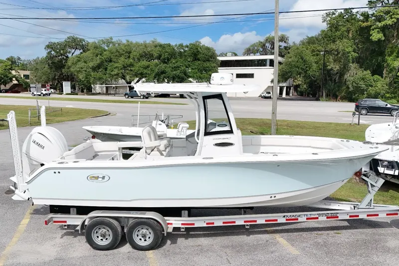The Image of 2023 Sea Hunt Ultra 255SE boat on trailer, parked outdoors, showcasing sleek design. - 0