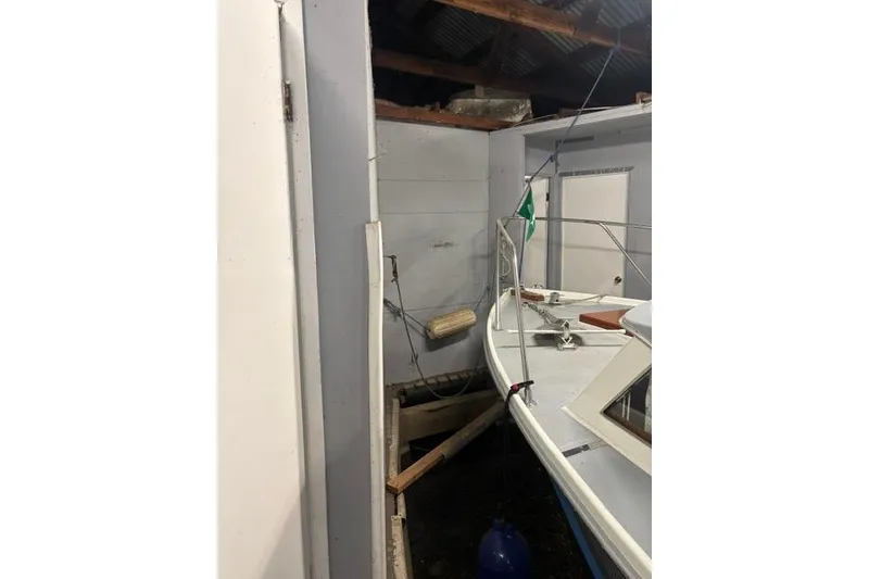 Slide: The Image of Boat docked inside a custom boathouse with wooden beams and white walls. - 12