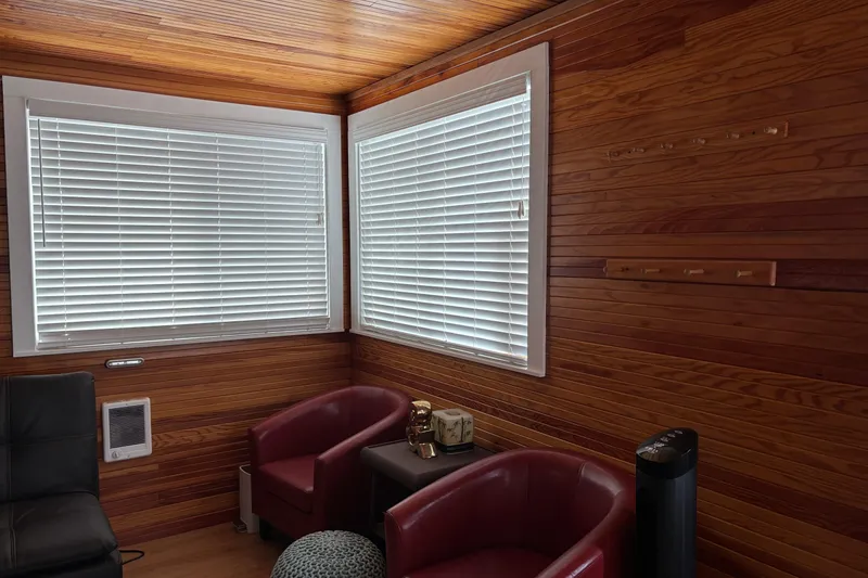 Slide: The Image of Wood-paneled room with red chairs, white blinds, and a small table. - 16