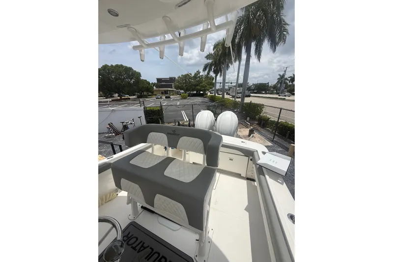 Slide: The Image of 2025 Regulator 25 boat interior with seating, palm trees, and street view in the background. - 17