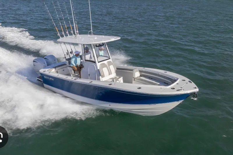 Slide: The Image of 2025 Regulator 25 boat cruising on open water with fishing rods and dual engines. - 2