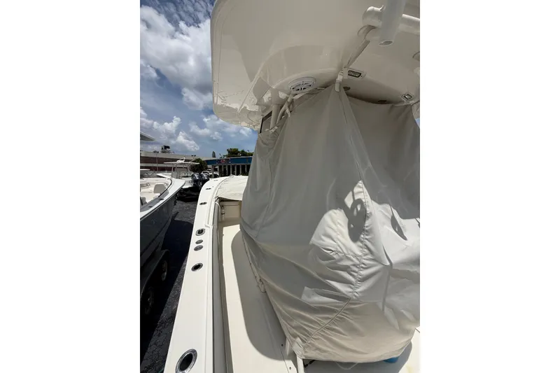 Slide: The Image of 2025 Regulator 25 boat with covered console, under a partly cloudy sky. - 25