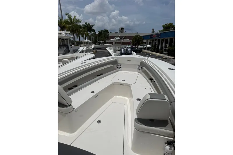 Slide: The Image of 2025 Regulator 25 boat interior with seating and storage, docked under a cloudy sky. - 21