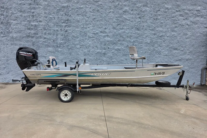 Slide: The Image of 1997 Lowe Bass Striker 170 boat on trailer, featuring Mercury outboard motor. - 2