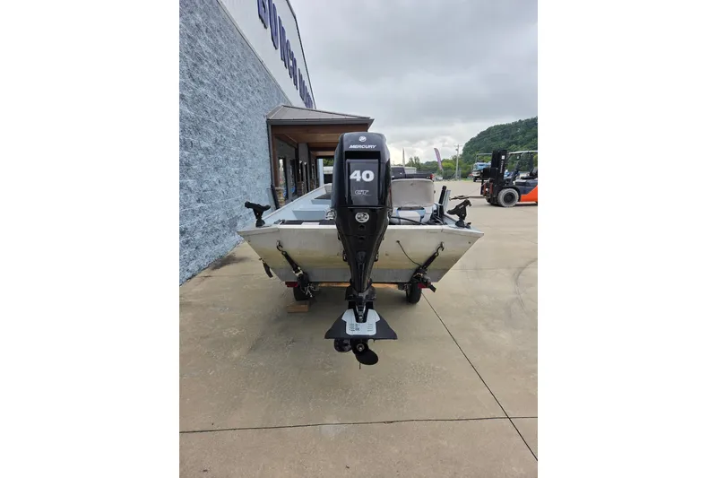 Slide: The Image of 1997 Lowe Bass Striker 170 boat with Mercury 40 HP engine, parked outdoors. - 5