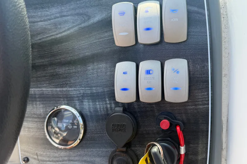 Slide: The Image of Control panel of 2019 Hurricane SunDeck 2400 OB boat with switches and gauges. - 32