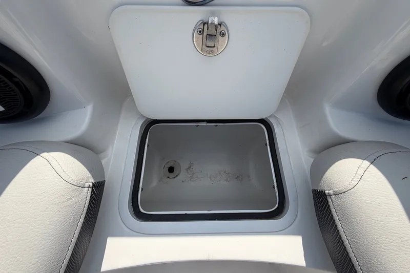 Slide: The Image of A white storage compartment with a drain in a boat, surrounded by cushioned seats. - 48