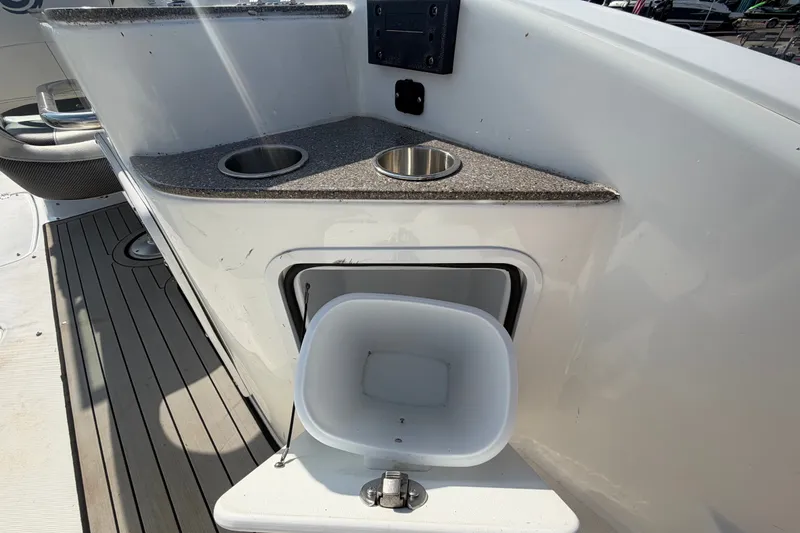 Slide: The Image of 2019 Hurricane SunDeck 2400 OB boat interior with cup holders and storage compartment. - 15