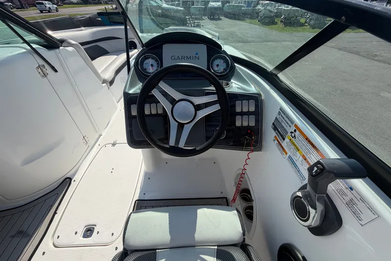 Slide: The Image of 2019 Hurricane SunDeck 2400 OB boat cockpit with Garmin navigation system and steering wheel. - 28