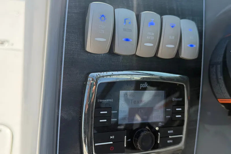 Slide: The Image of Control panel of a 2019 Hurricane SunDeck 2400 OB boat with stereo and switches. - 31
