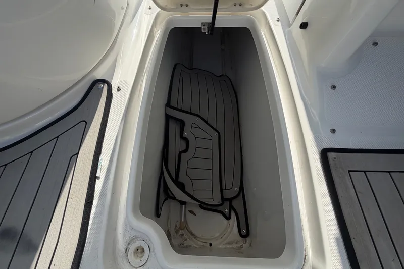 Slide: The Image of An open storage compartment on a boat with black mats inside. - 37