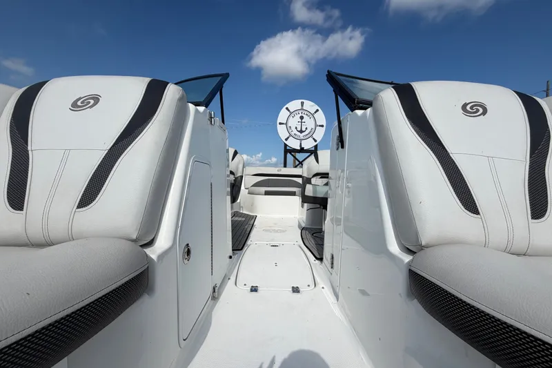 Slide: The Image of 2019 Hurricane SunDeck 2400 OB boat interior with white seating under blue sky. - 55