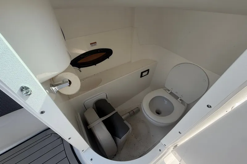Slide: The Image of 2019 Hurricane SunDeck 2400 OB boat bathroom with toilet and storage space. - 25