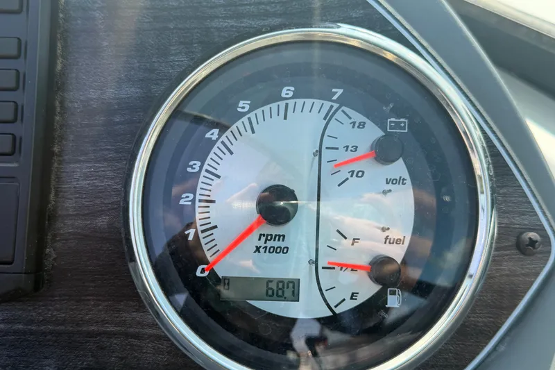 Slide: The Image of Close-up of 2019 Hurricane SunDeck 2400 OB dashboard gauges showing RPM, voltage, and fuel levels. - 34