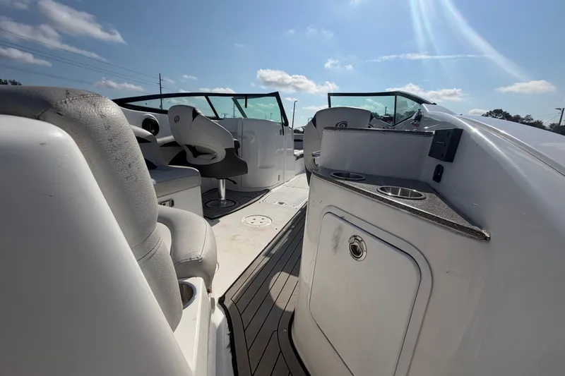 Slide: The Image of 2019 Hurricane SunDeck 2400 OB boat interior with seating and console under sunny sky. - 14