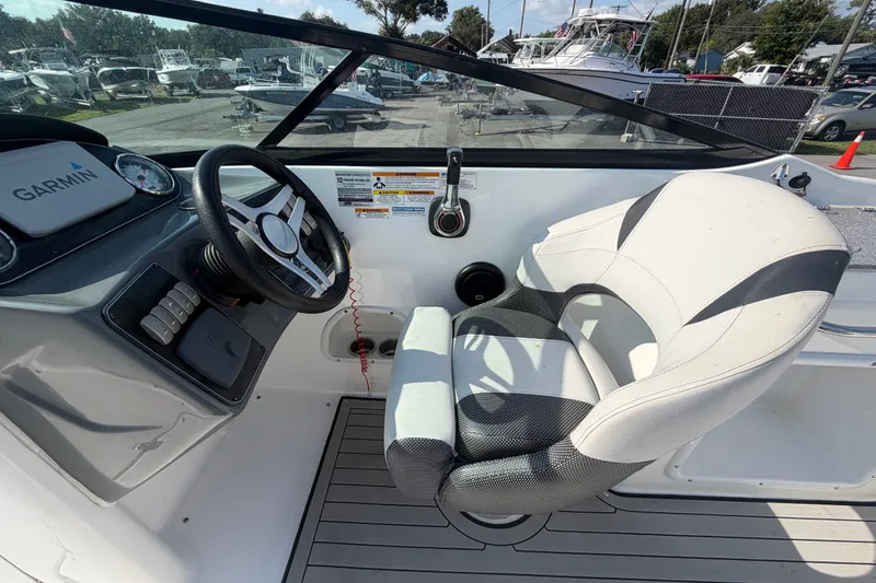 Slide: The Image of 2019 Hurricane SunDeck 2400 OB boat cockpit with steering wheel and Garmin navigation system. - 27