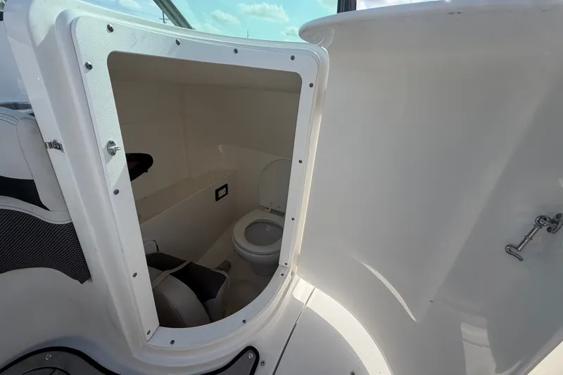Slide: The Image of 2019 Hurricane SunDeck 2400 OB boat interior with compact marine toilet. - 24
