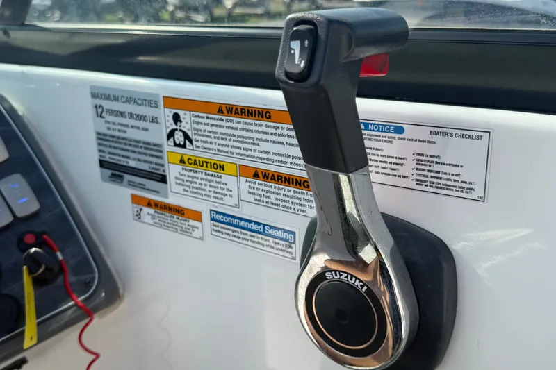 Slide: The Image of Throttle control and warning labels on a 2019 Hurricane SunDeck 2400 OB boat. - 33