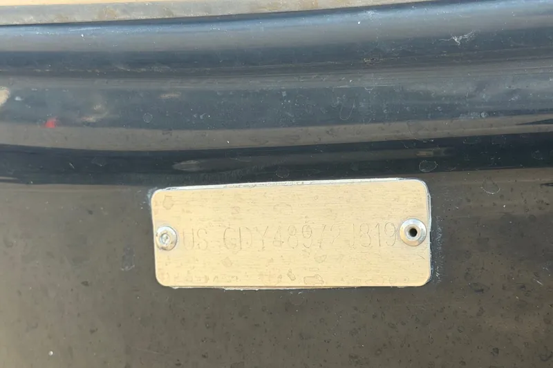 Slide: The Image of 2019 Hurricane SunDeck 2400 OB boat identification plate on a dark surface. - 77