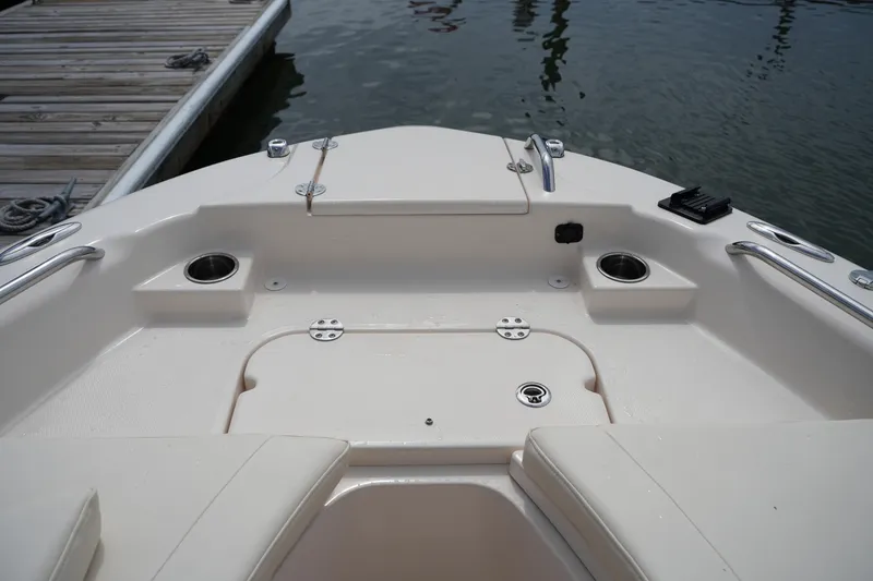 Slide: The Image of 2021 Grady-White 251 Coastal Explorer boat interior, featuring seating and cup holders by the dock. - 31