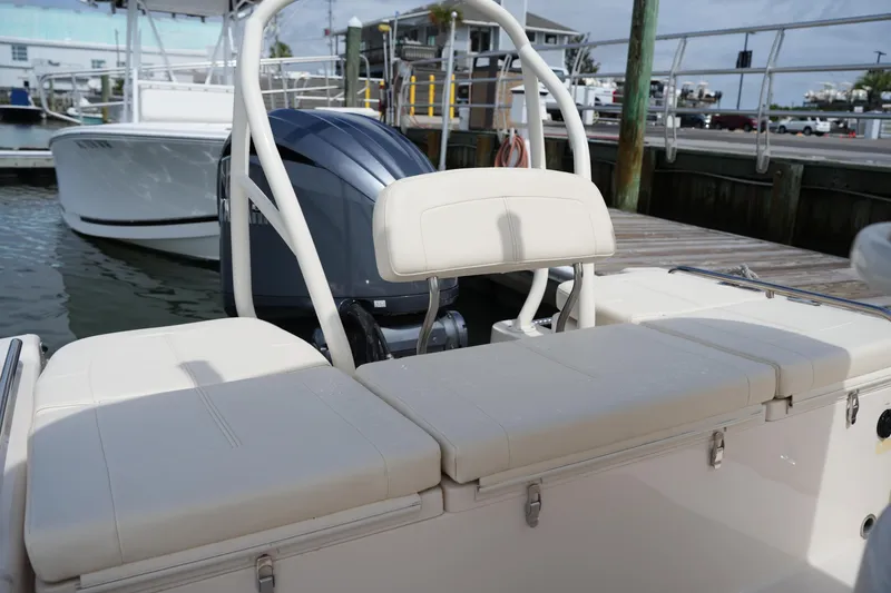 Slide: The Image of 2021 Grady-White 251 Coastal Explorer boat interior with cushioned seating and outboard motor. - 14
