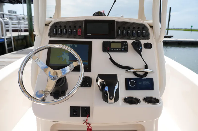 Slide: The Image of 2021 Grady-White 251 Coastal Explorer boat dashboard with steering wheel and navigation controls. - 18