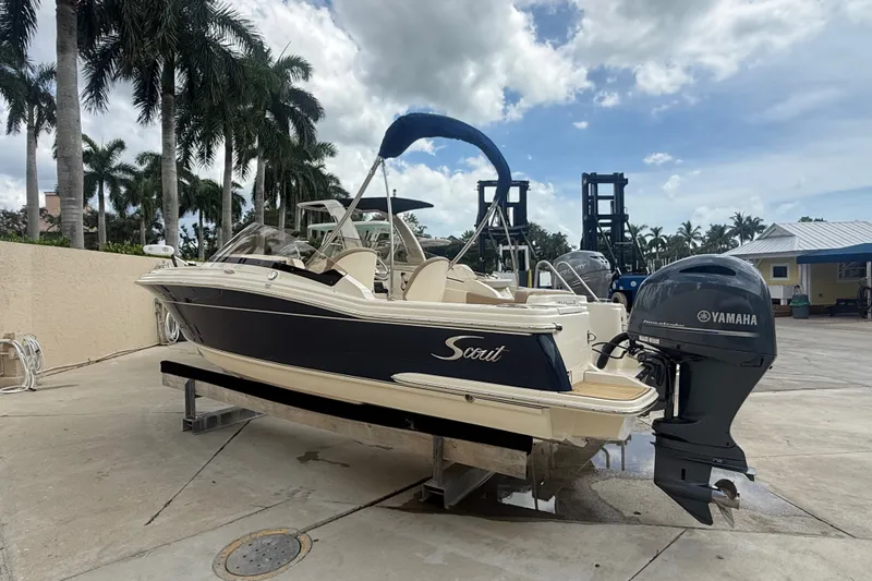 The Image of 2022 Scout 215 Dorado boat with Yamaha engine on a dock under a cloudy sky. - 0