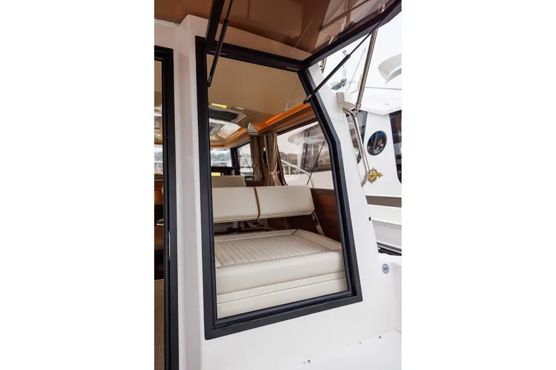 Slide: The Image of 2026 Ranger Tugs R-27 interior seating area with modern design and comfortable upholstery. - 18