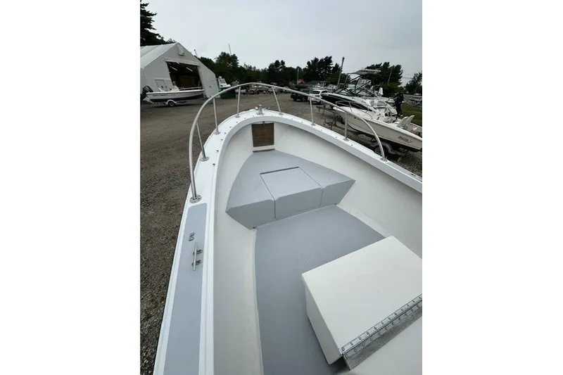 Slide: The Image of 1975 F L Tripp & Sons 18 Center Console boat, docked, showcasing spacious deck and seating. - 12