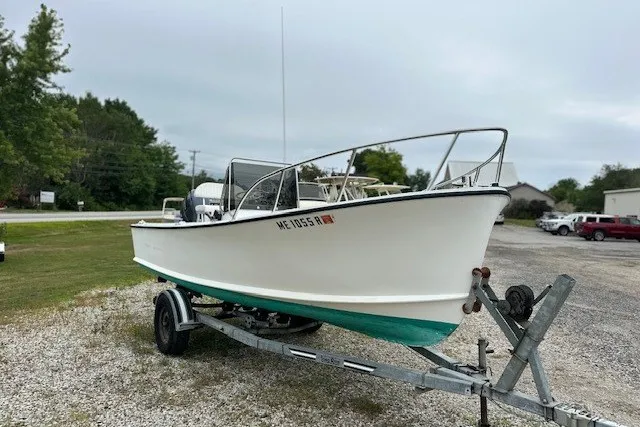 Slide: The Image of 1975 F L Tripp & Sons 18 Center Console boat on trailer in a parking area. - 2