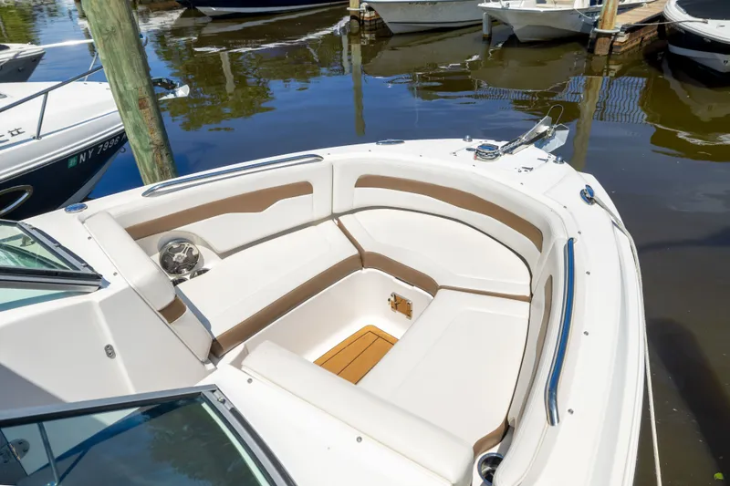 Slide: The Image of 2015 Chaparral 246 SSi boat with spacious seating, docked in a marina. - 27