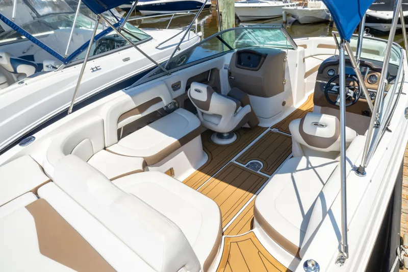 Slide: The Image of 2015 Chaparral 246 SSi boat interior with seating, steering wheel, and wood-style flooring. - 25