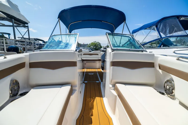 Slide: The Image of 2015 Chaparral 246 SSi boat interior with seating and canopy under clear sky. - 21