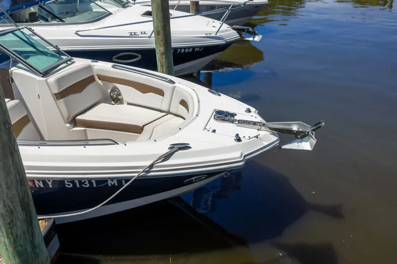 Slide: The Image of 2015 Chaparral 246 SSi boat docked in calm waters, featuring sleek design and comfortable seating. - 17