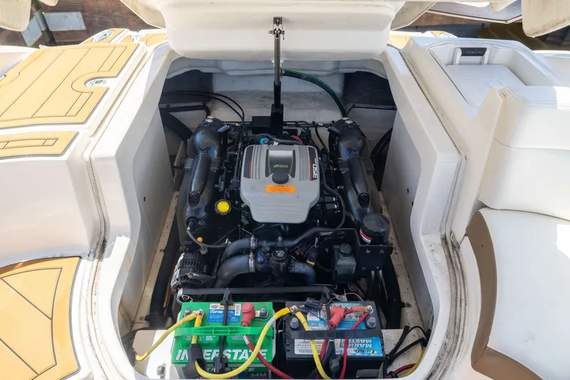 Slide: The Image of Engine compartment of a 2015 Chaparral 246 SSi boat, showcasing the motor and battery. - 28