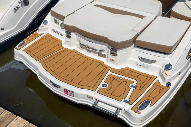 Slide: The Image of 2015 Chaparral 246 SSi boat with tan deck and seating, docked on water. - 23