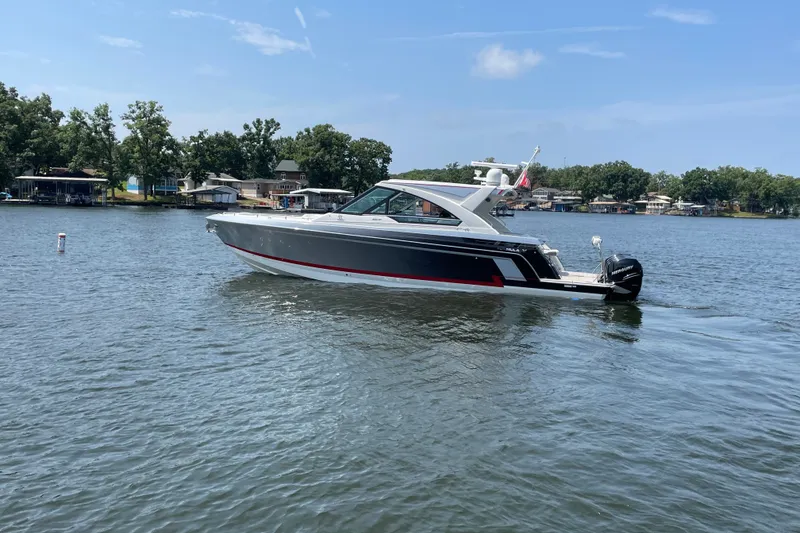 Slide: The Image of 2021 Formula 430 Super Sport Crossover boat cruising on a serene lake. - 17