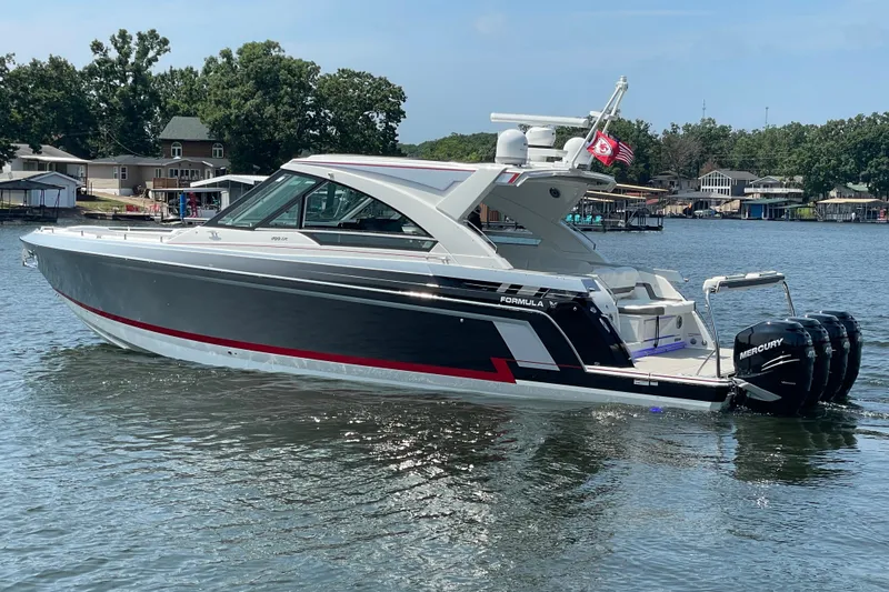 Slide: The Image of 2021 Formula 430 Super Sport Crossover boat on a lake, featuring sleek design and powerful engines. - 18