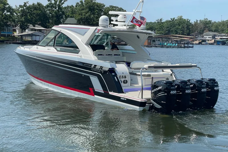 Slide: The Image of 2021 Formula 430 Super Sport Crossover boat with four Mercury 400 engines on a lake. - 21