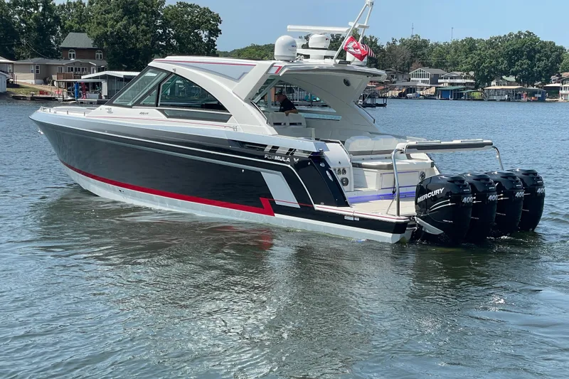 Slide: The Image of 2021 Formula 430 Super Sport Crossover boat on a lake with four Mercury engines. - 20