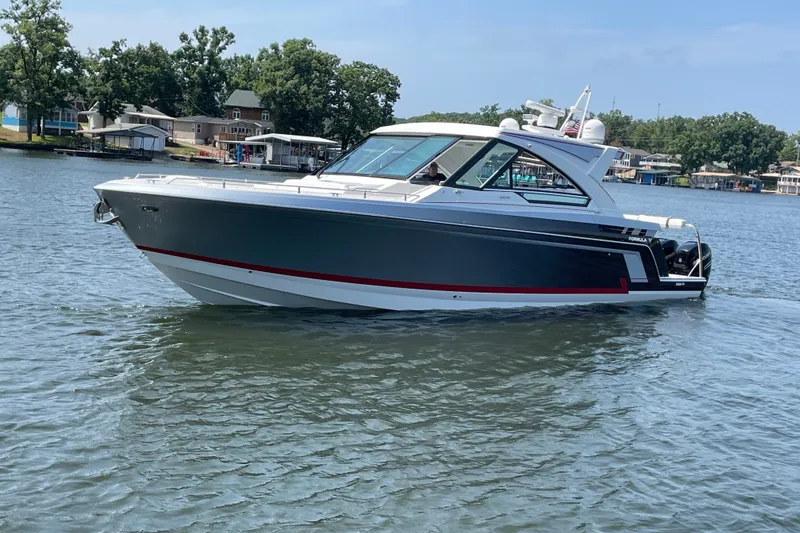 Slide: The Image of 2021 Formula 430 Super Sport Crossover boat cruising on a serene lake. - 14