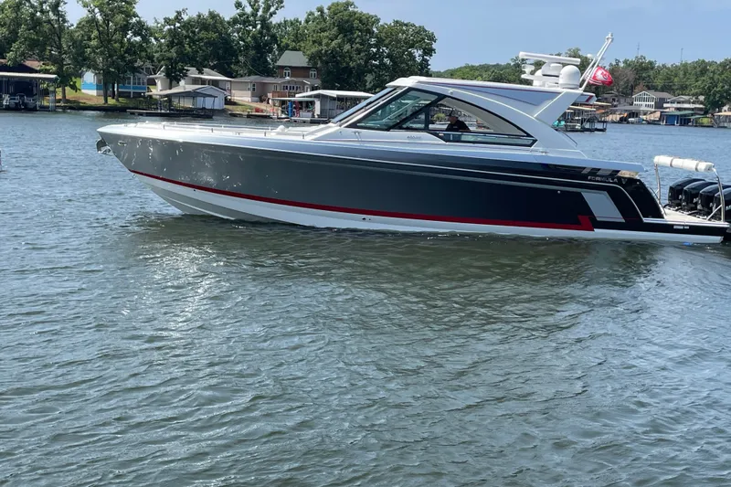 Slide: The Image of 2021 Formula 430 Super Sport Crossover boat on a lake with trees and houses in background. - 16