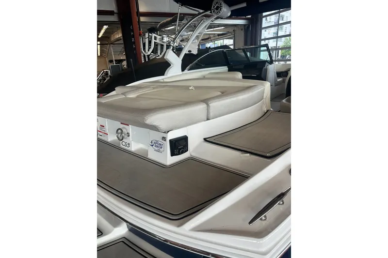 Slide: The Image of 2020 Cobalt CS23 Surf boat with cushioned seating and sleek design in a showroom. - 19
