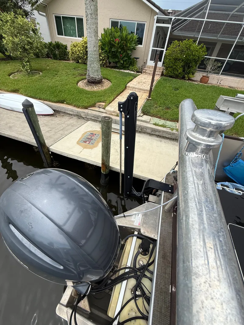 Slide: The Image of A boat with an outboard motor is docked in front of a house with a garden. - 14