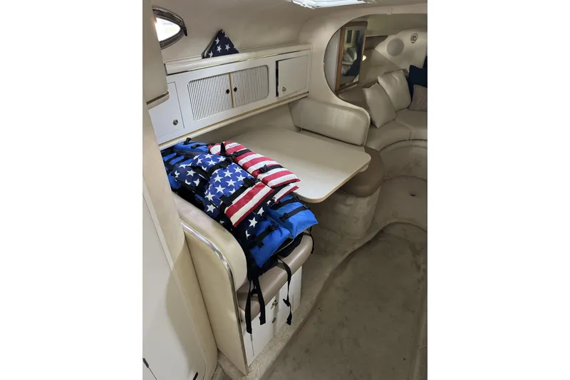 Slide: The Image of Interior of 2000 Sea Ray 290 Sundancer with American flag life jackets on seating area. - 13