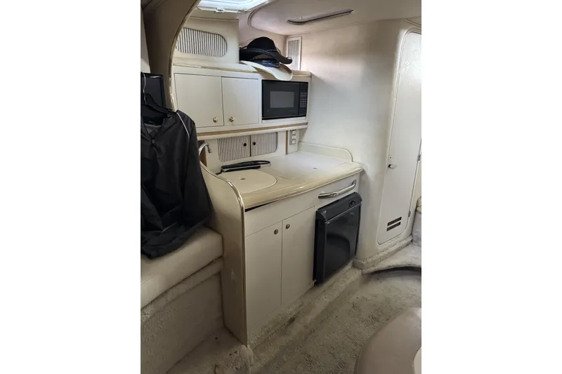 Slide: The Image of Interior of 2000 Sea Ray 290 Sundancer with kitchenette and storage cabinets. - 10