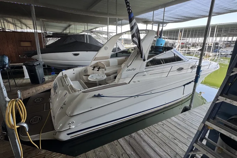 The Image of 2000 Sea Ray 290 Sundancer docked in a marina, showcasing sleek design and spacious deck. - 1
