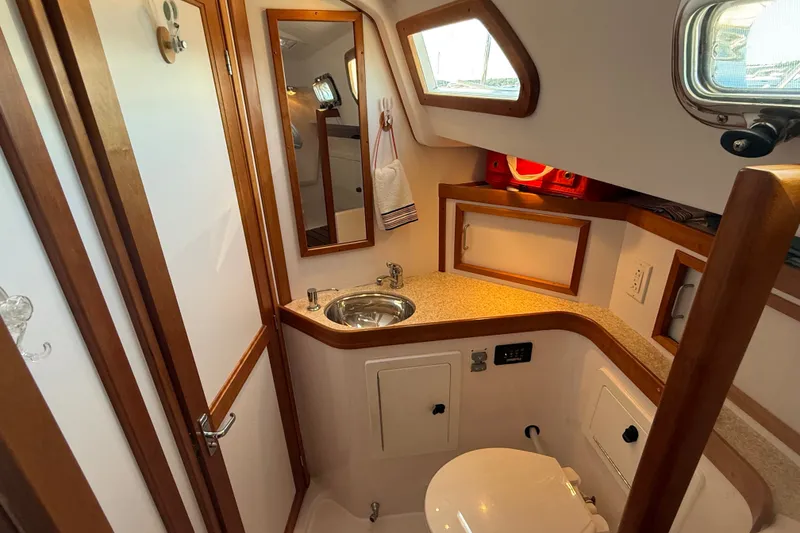 Slide: The Image of Interior of 2009 Sabre 386 yacht bathroom with sink, mirror, and wooden accents. - 48