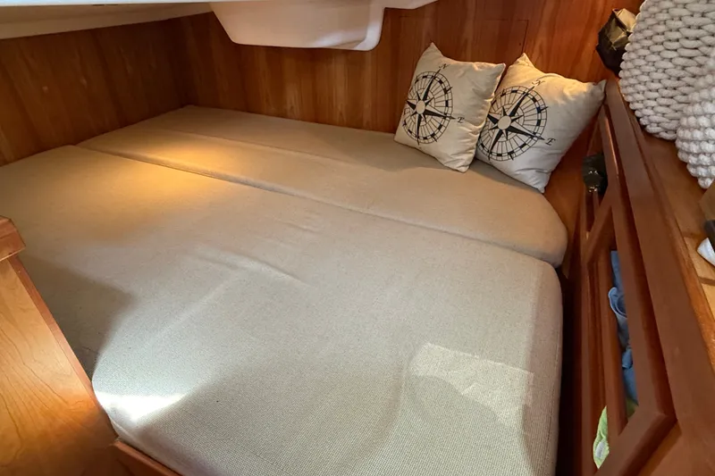 Slide: The Image of Cozy cabin bed in 2009 Sabre 386 sailboat with compass-themed pillows. - 60